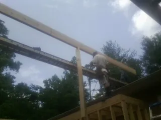 Carpenter setting a ridge beam over a new addition frame — Ice Dam Removal by Roofing Brothers in Inchelium